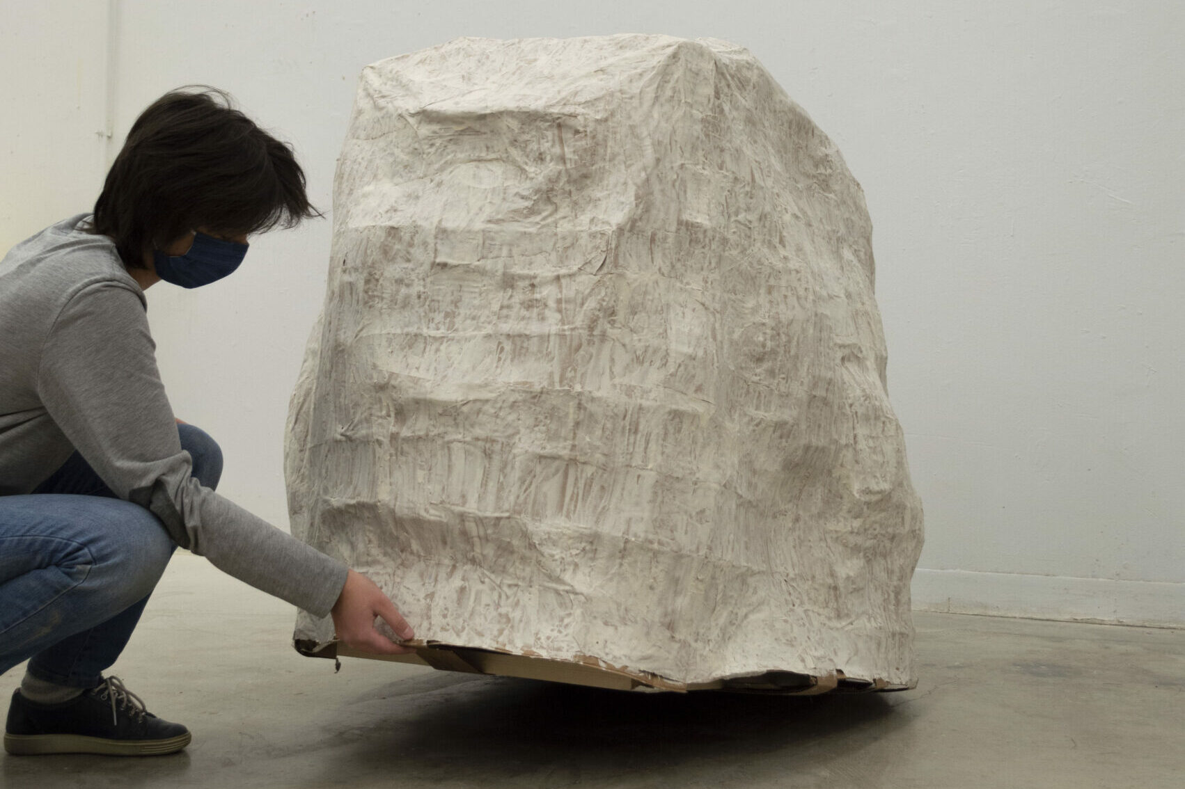 Ella interacts with her paper mache sculpture: The Boulder